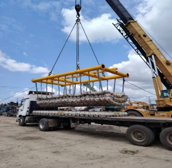 Concrete mattress lifted by crane for marine installation